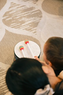 A baby exploring a set of small drums
