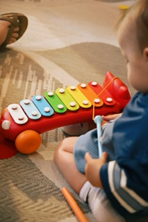 A baby trying out a percussion instrument